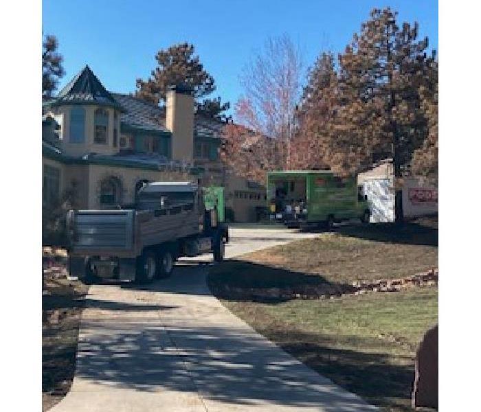 SERVPRO trucks outside home with water damage.